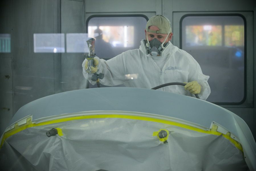 Technician Wearing Protective Suit Painting Car Panel | D&V Autobody