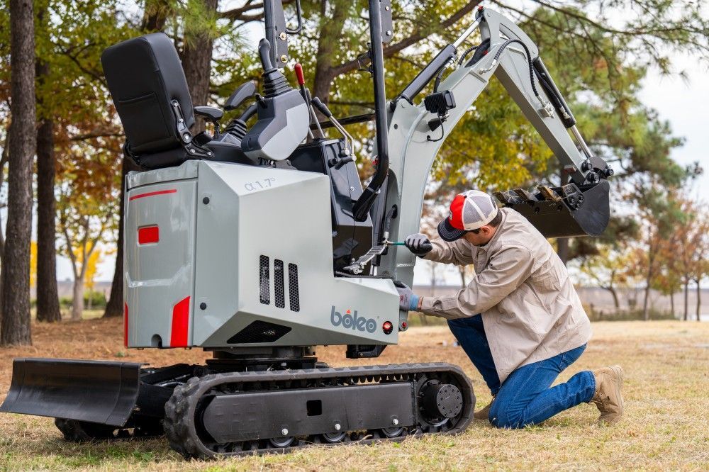 Person Working On A Small, Gray Excavator — Allquip Rentals Pty Ltd in Cooroy, QLD