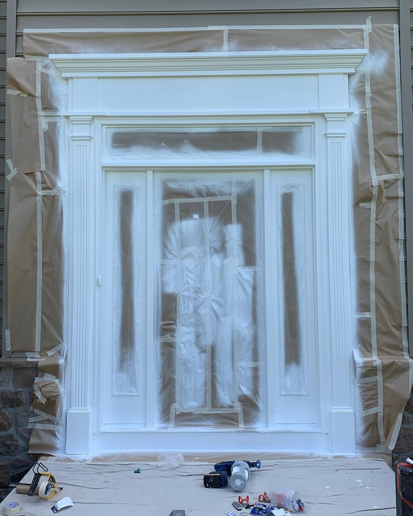 The front door of a house is being painted white.