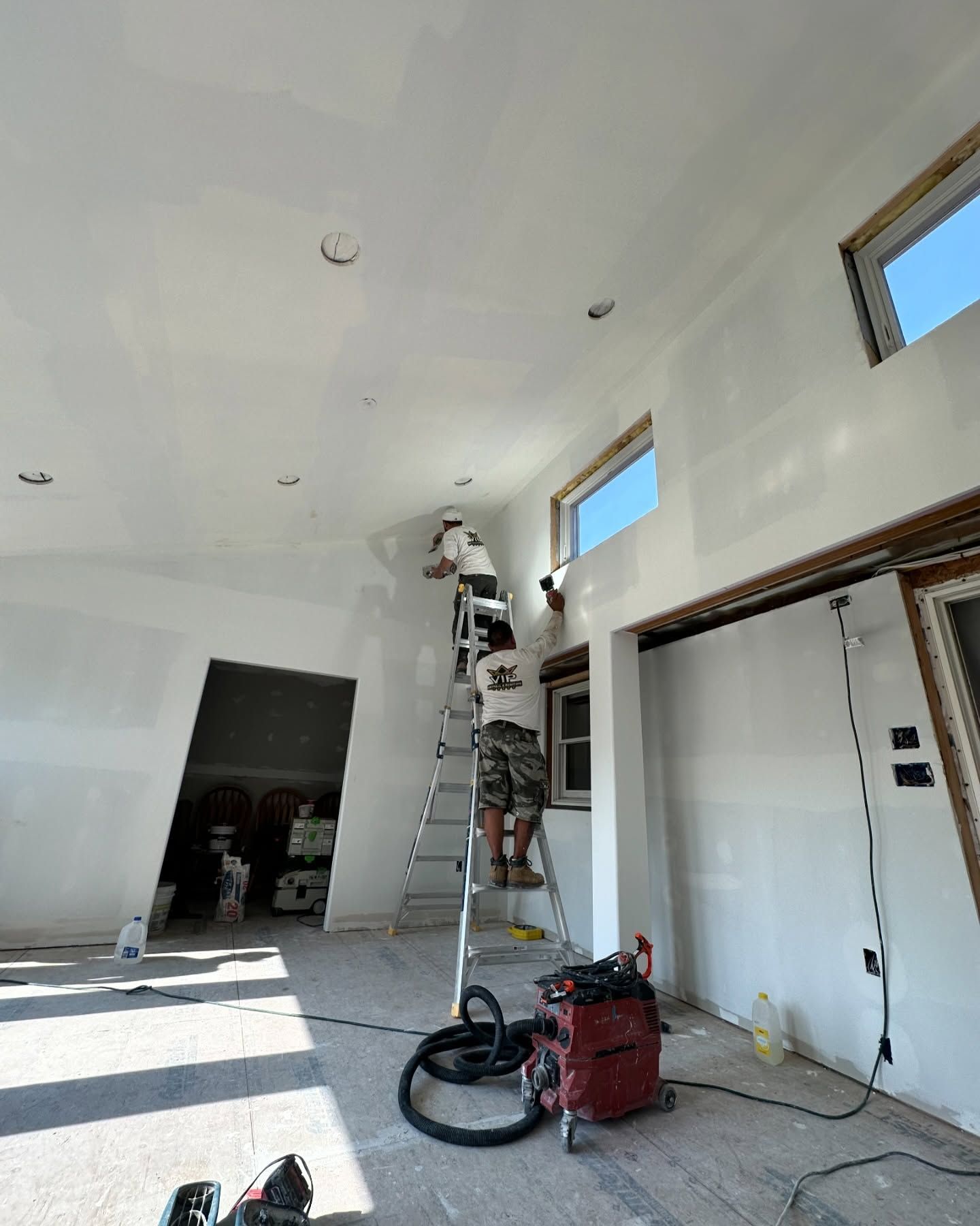 A man is standing on a ladder in a room.