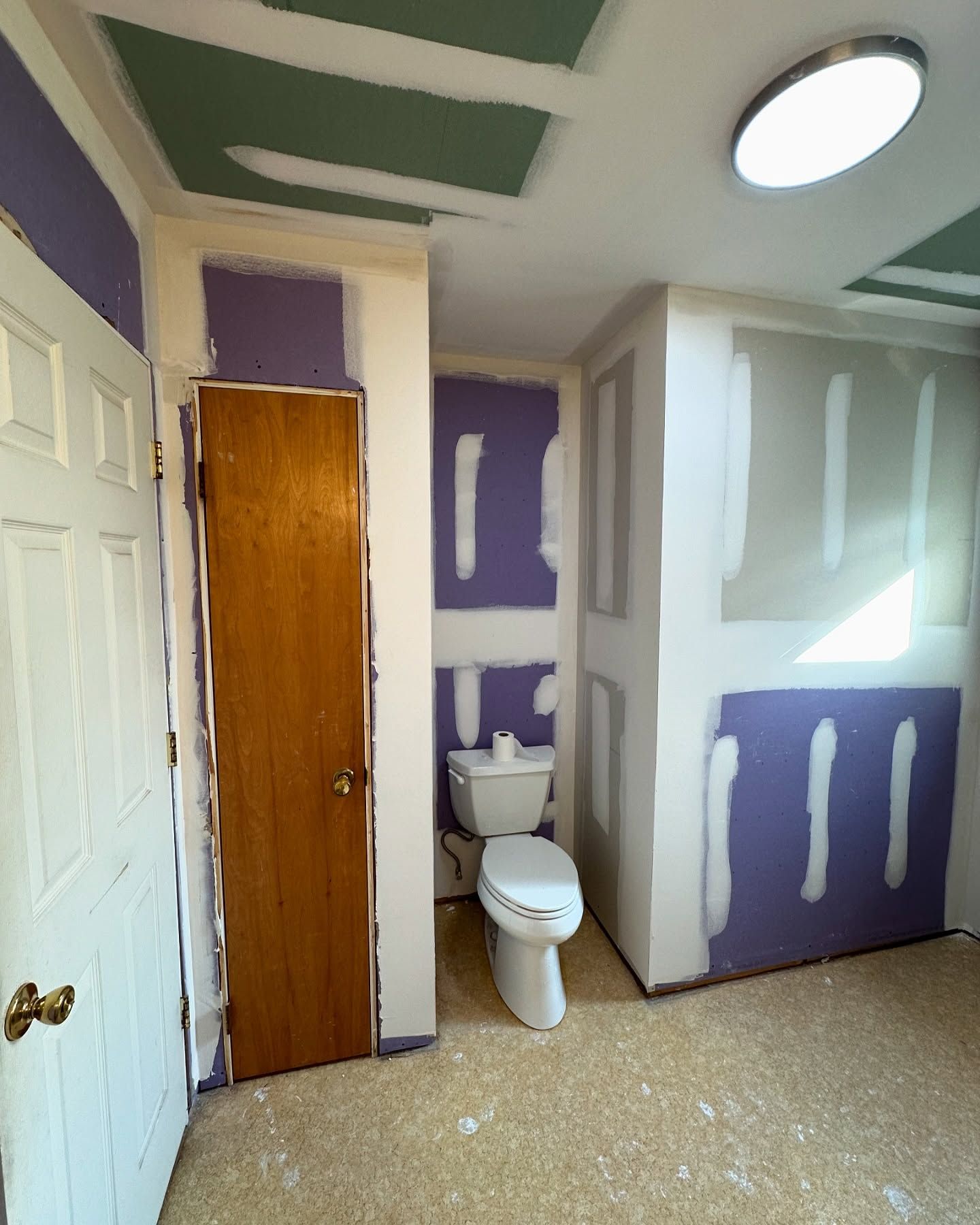 A bathroom with purple walls and a toilet