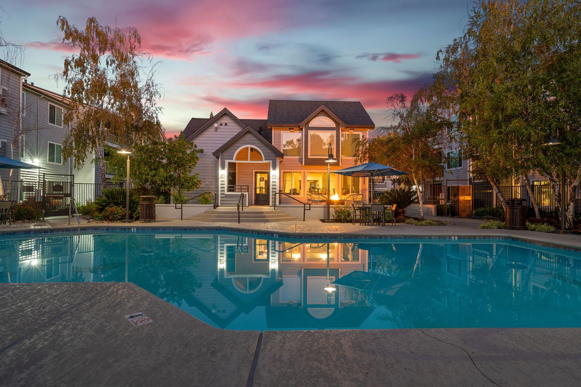 Outdoor pool area at a multifamily community at dusk with a clubhouse and seating at The Reserve at Capital Center.