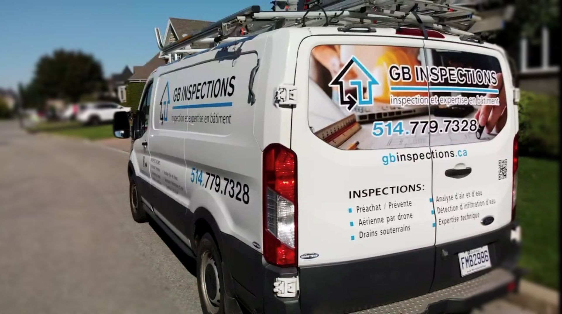 Fourgonnette blanche, logo « Gain Inspections », stationnée dans la rue. Galerie de toit, environnement résidentiel,