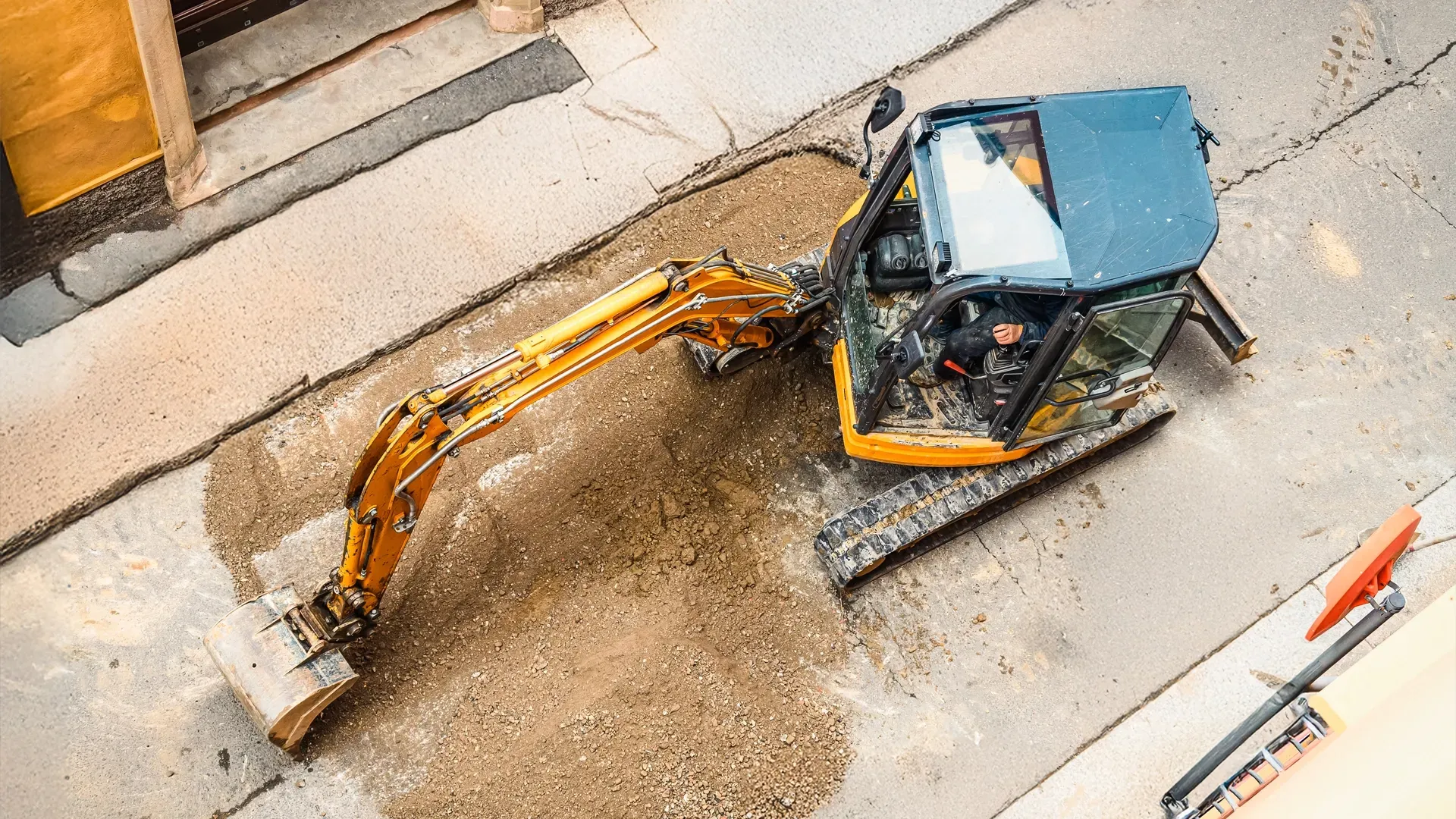 Compact excavator in action on a narrow urban job site