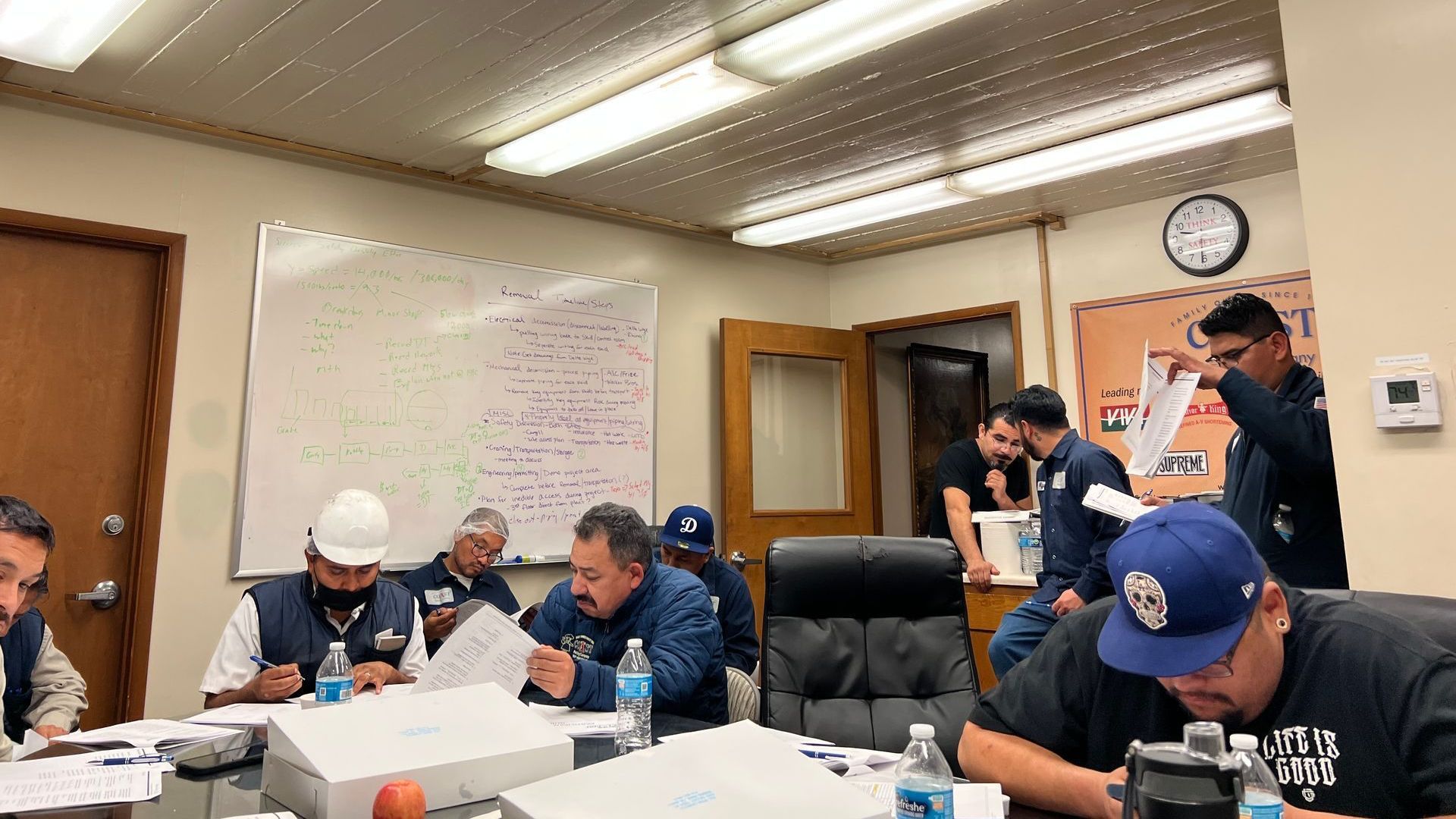 A group of men are sitting around a table in a conference room.