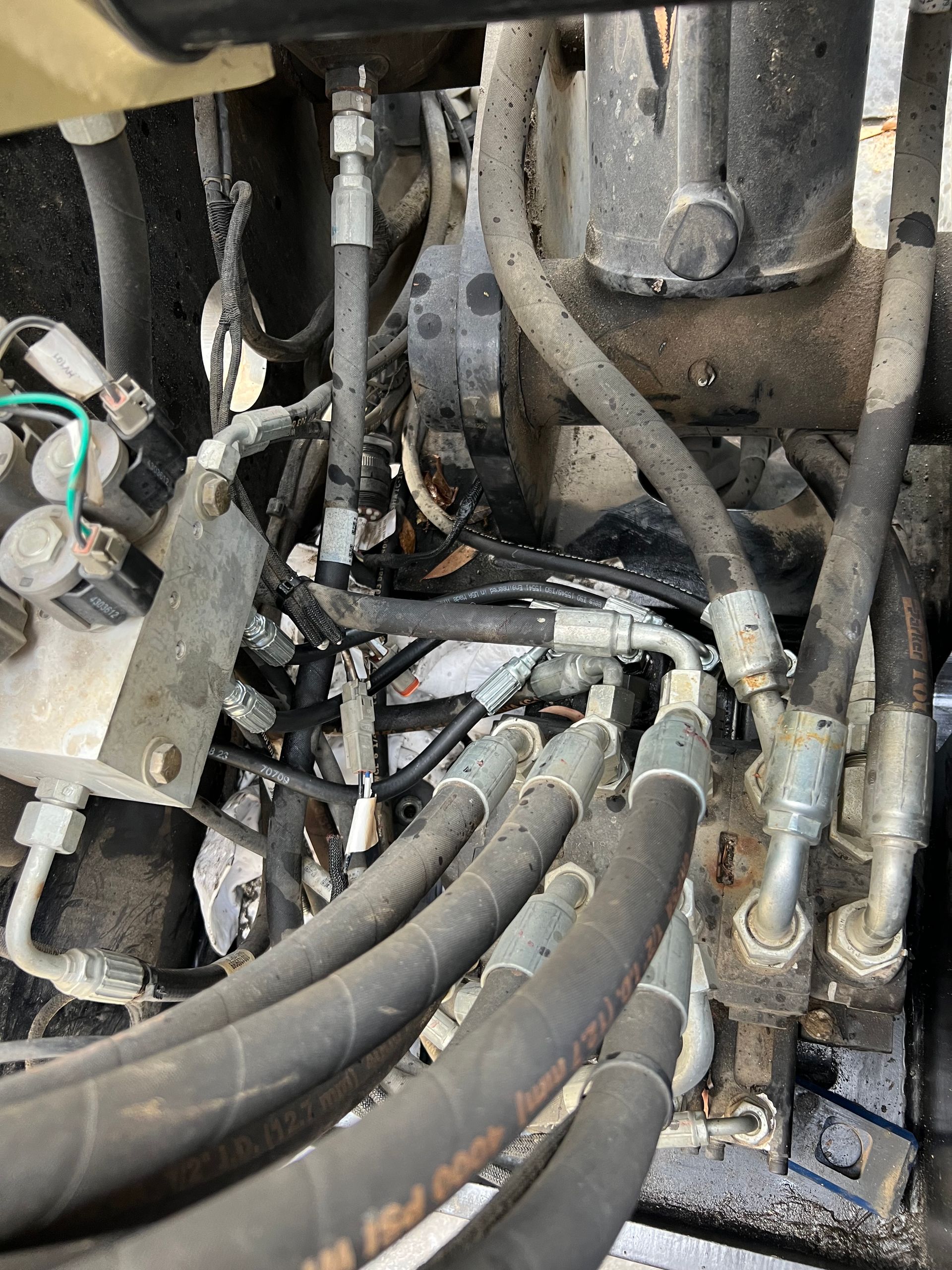 A bunch of hydraulic hoses are connected to a machine.