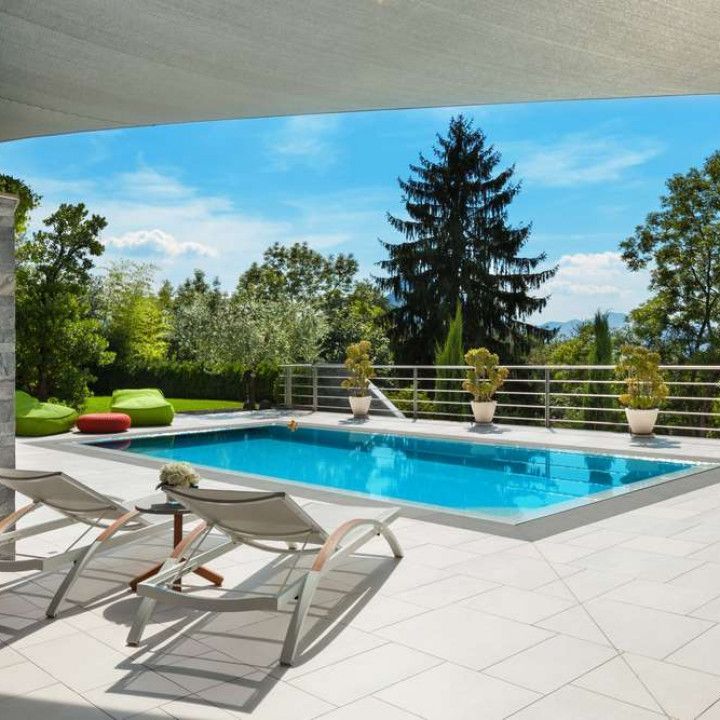 A large swimming pool surrounded by chairs and trees
