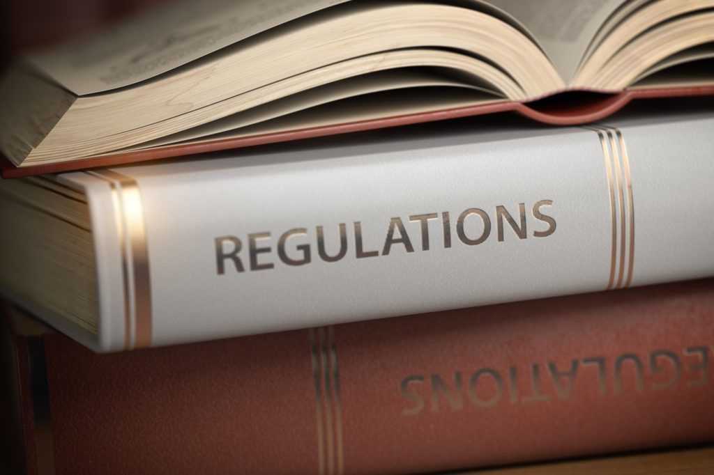 A stack of books with one titled regulations A stack of books with one titled regulations