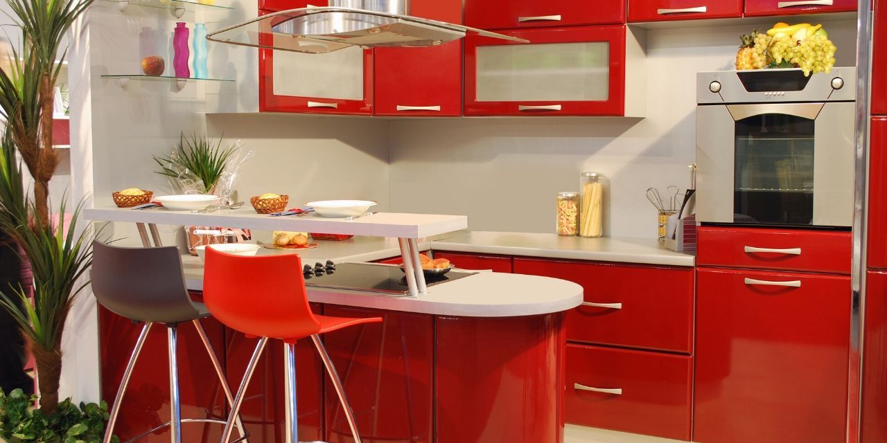 A kitchen with red cabinets and a white countertop.