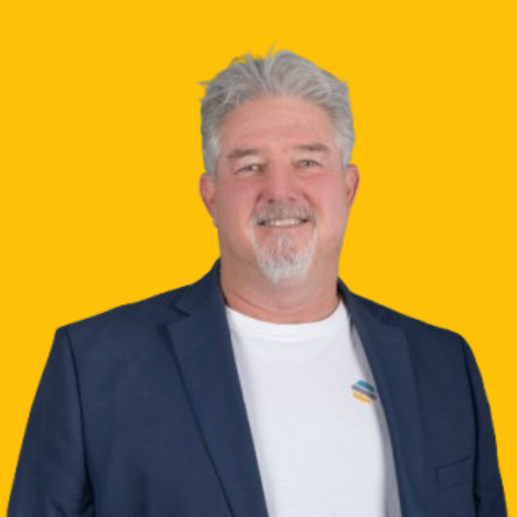 Buzz Howard, smiling wearing a white t-shirt and a blue blazer on a yellow background | Mortgage Lender in Roseville, CA