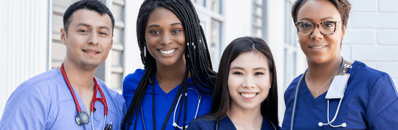 A group of doctors and nurses are posing for a picture together.