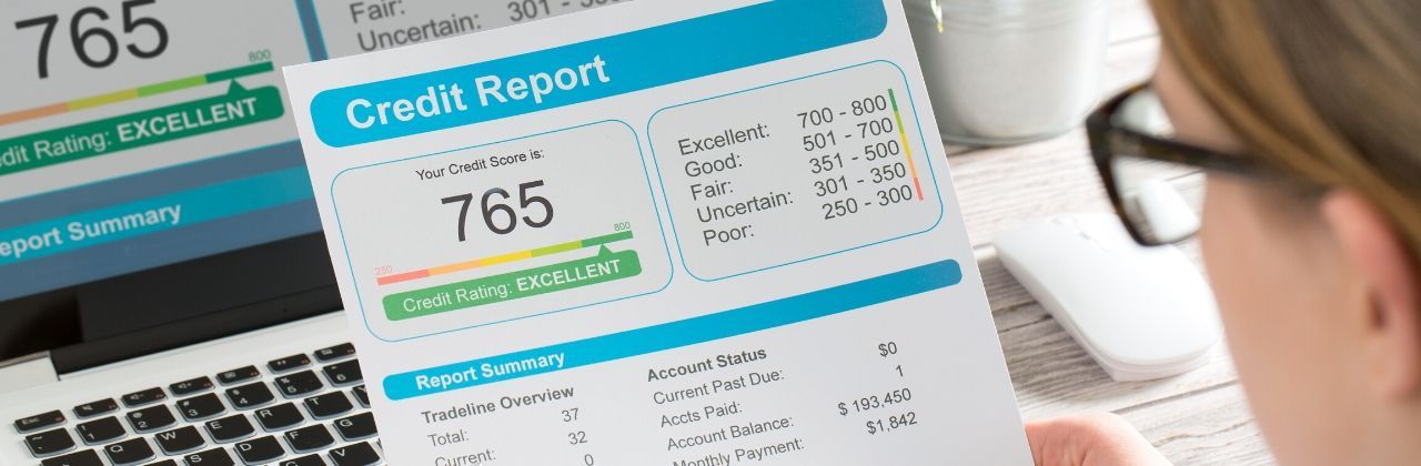 Person reviewing a credit report with an excellent credit score of 765.