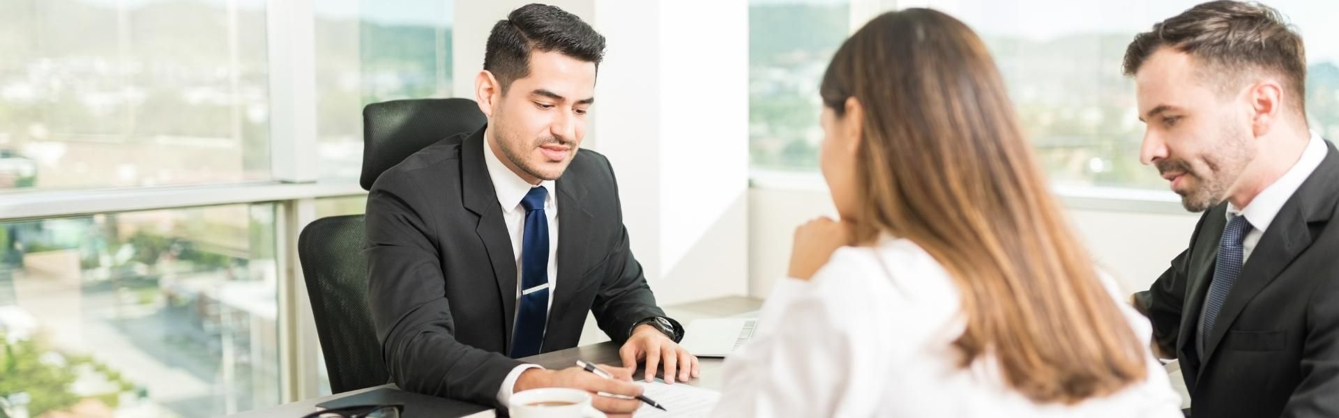 A group of people are sitting around a table having a meeting.