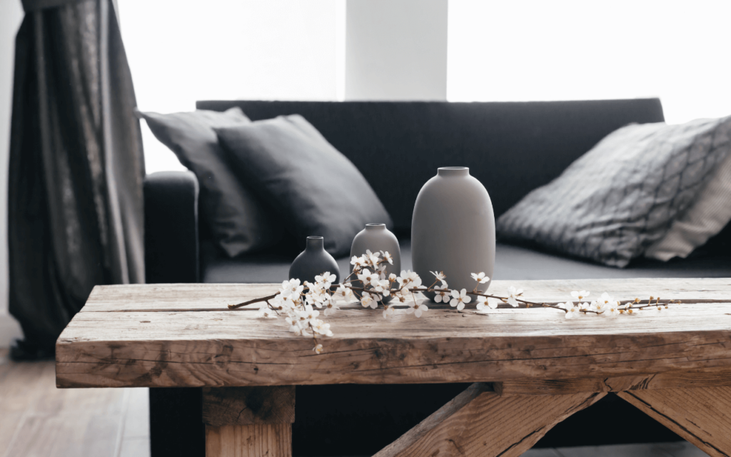 A wooden table with vases and flowers on it in front of a couch | Home loans in Roseville, CA