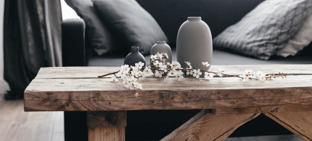 A wooden table with vases and flowers on it in front of a couch | Home loans in Roseville, CA