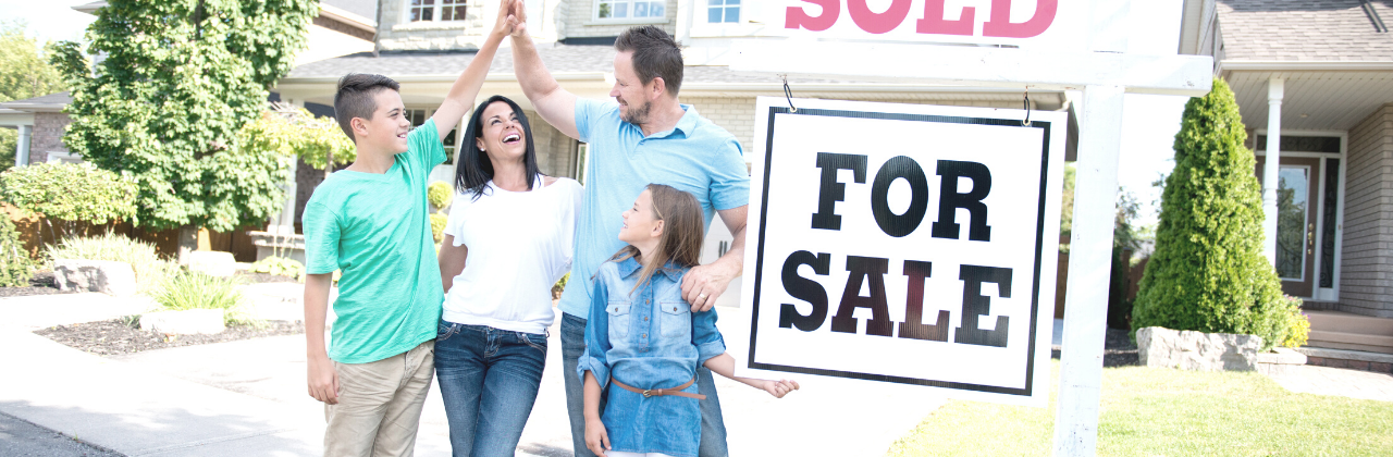 Family celebrating in front of a house with a 