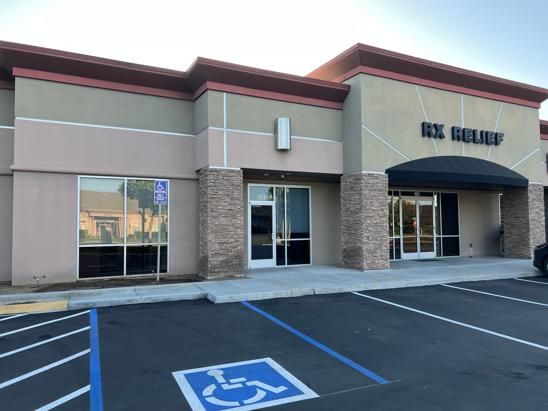 Exterior of a modern storefront with stone accents, large windows, and a parking lot | Mortgage Company in Roseville, CA