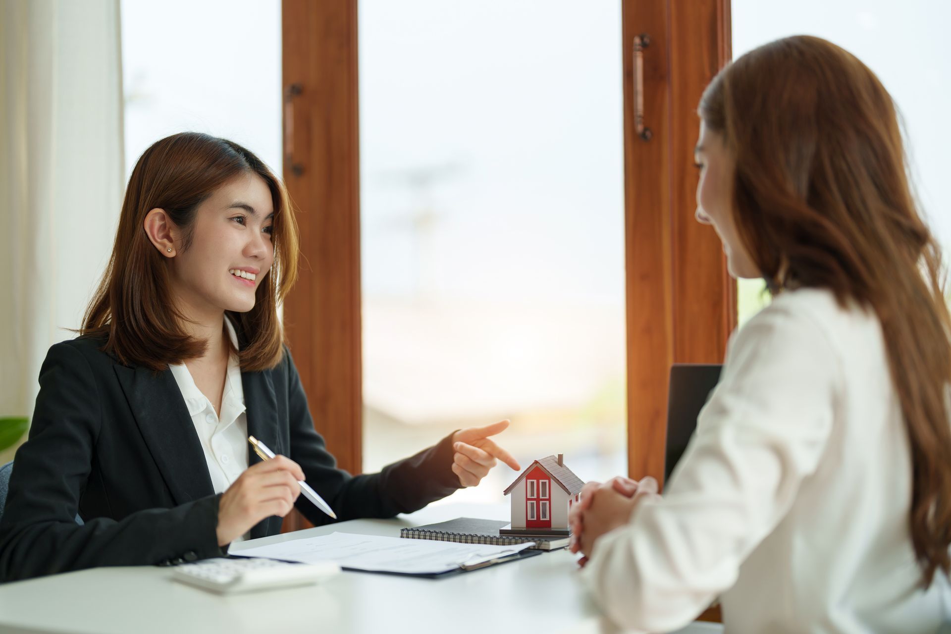 A woman is sitting at a table talking to another woman.