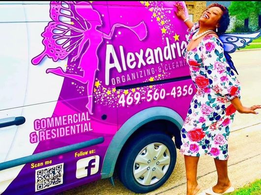A woman standing in front of a purple van that says alexandria