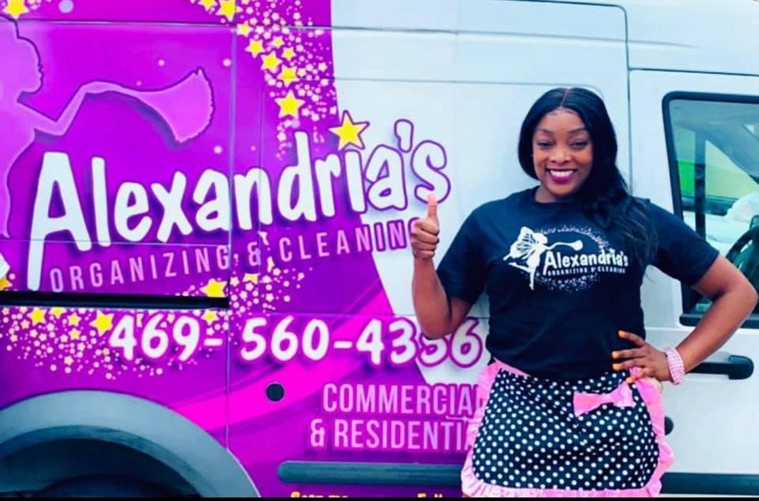 A woman is standing in front of a alexandria 's cleaning truck