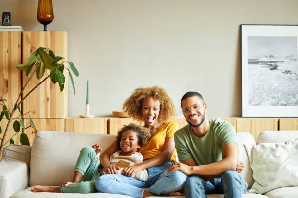 A Family Is Sitting On A Couch In A Living Room - Rochester, MN - Gibbons Optical