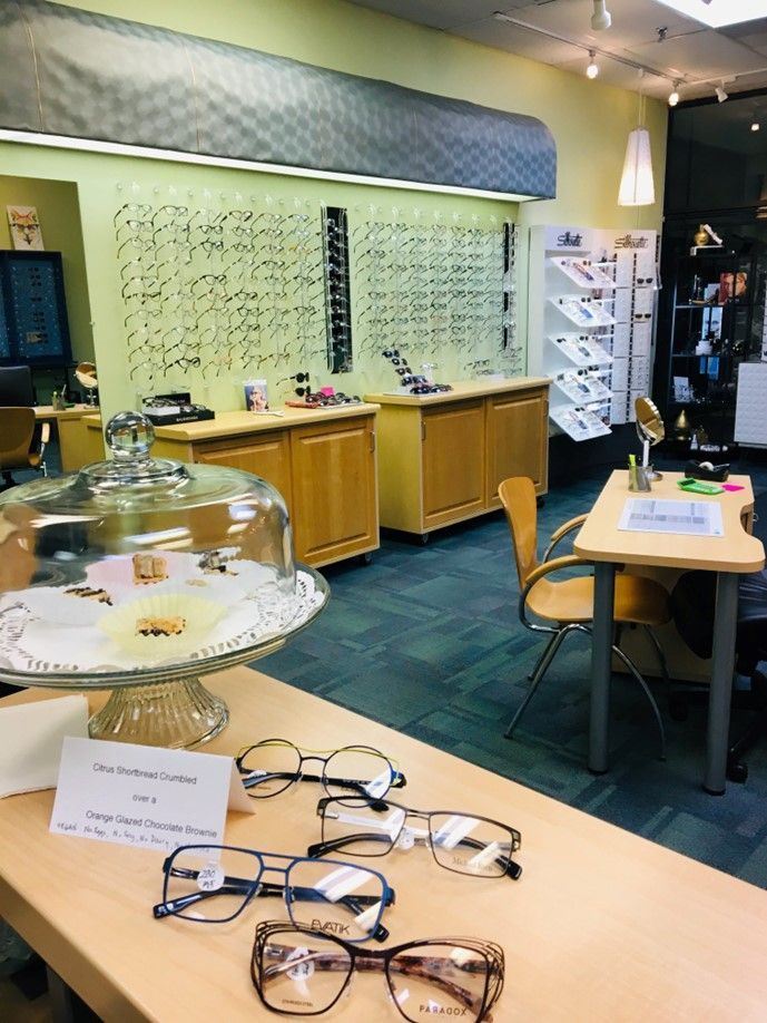 A table with glasses and a cake on it in an optical shop