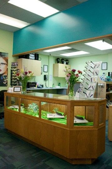 A long wooden counter in a store with flowers on it