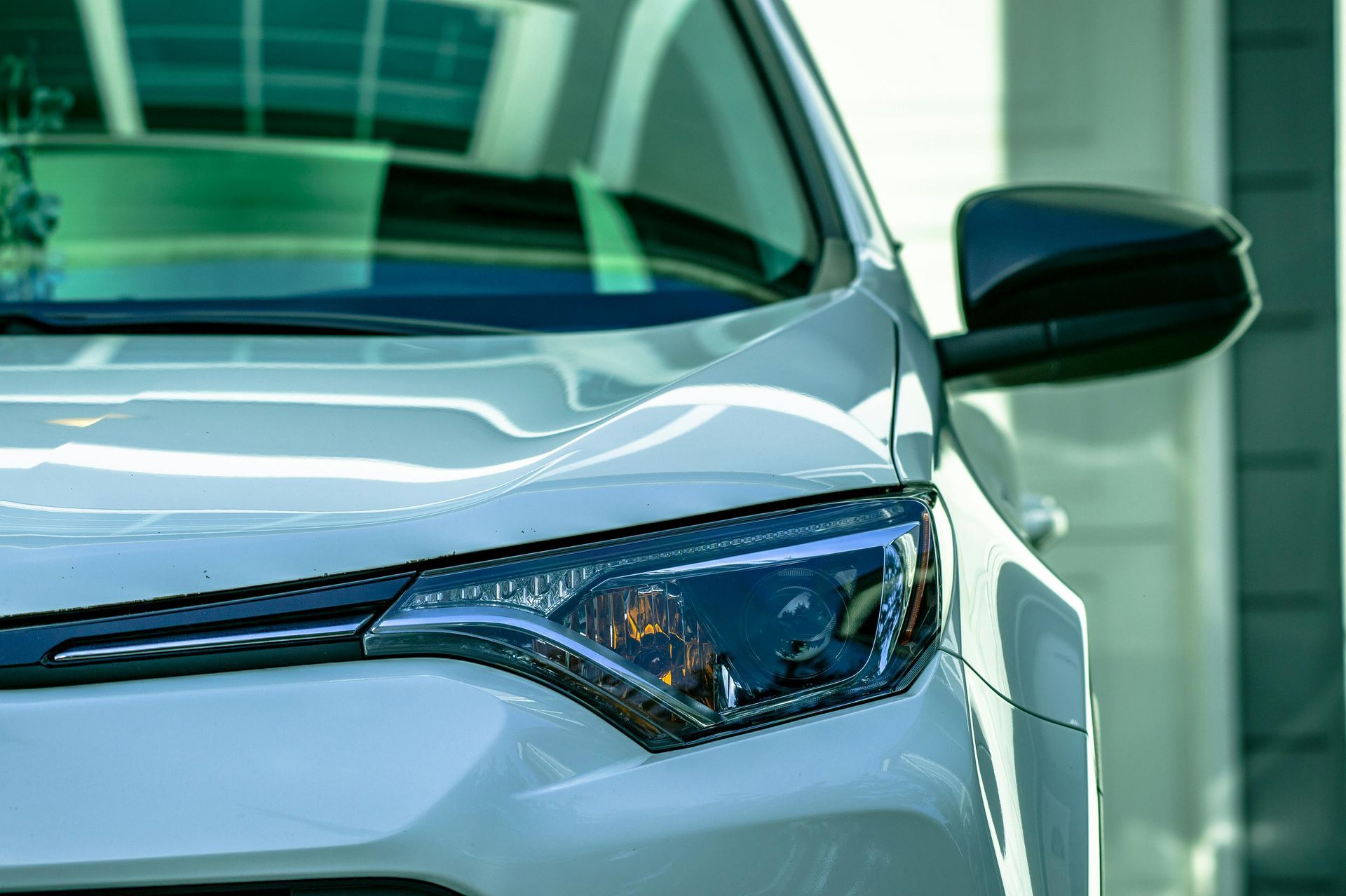 A close up of a white car parked in front of a building.