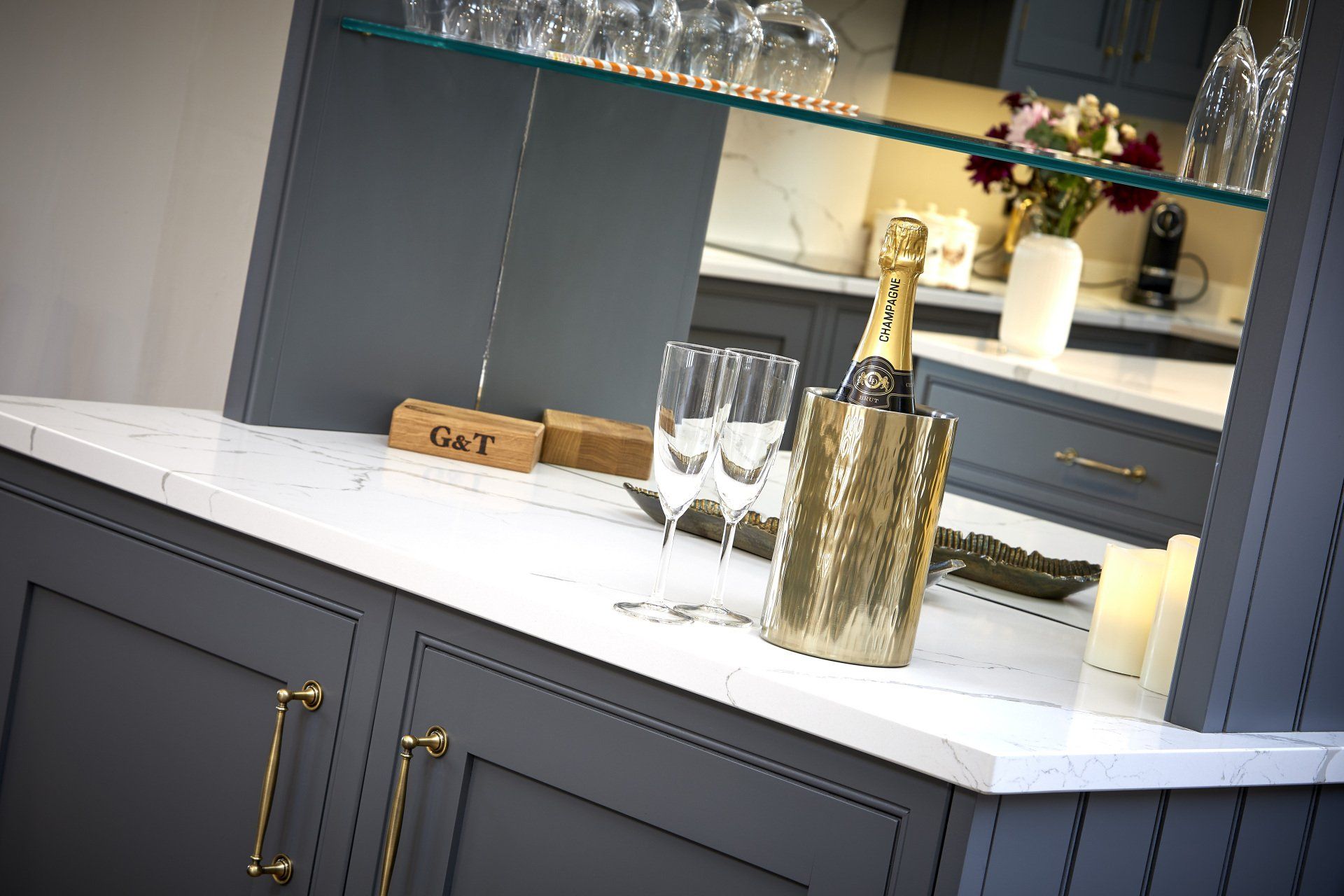 A kitchen counter with a bottle of champagne and glasses on it.