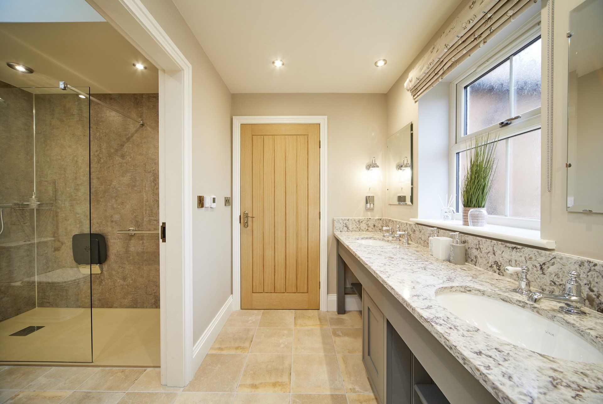 A bathroom with two sinks and a walk in shower.