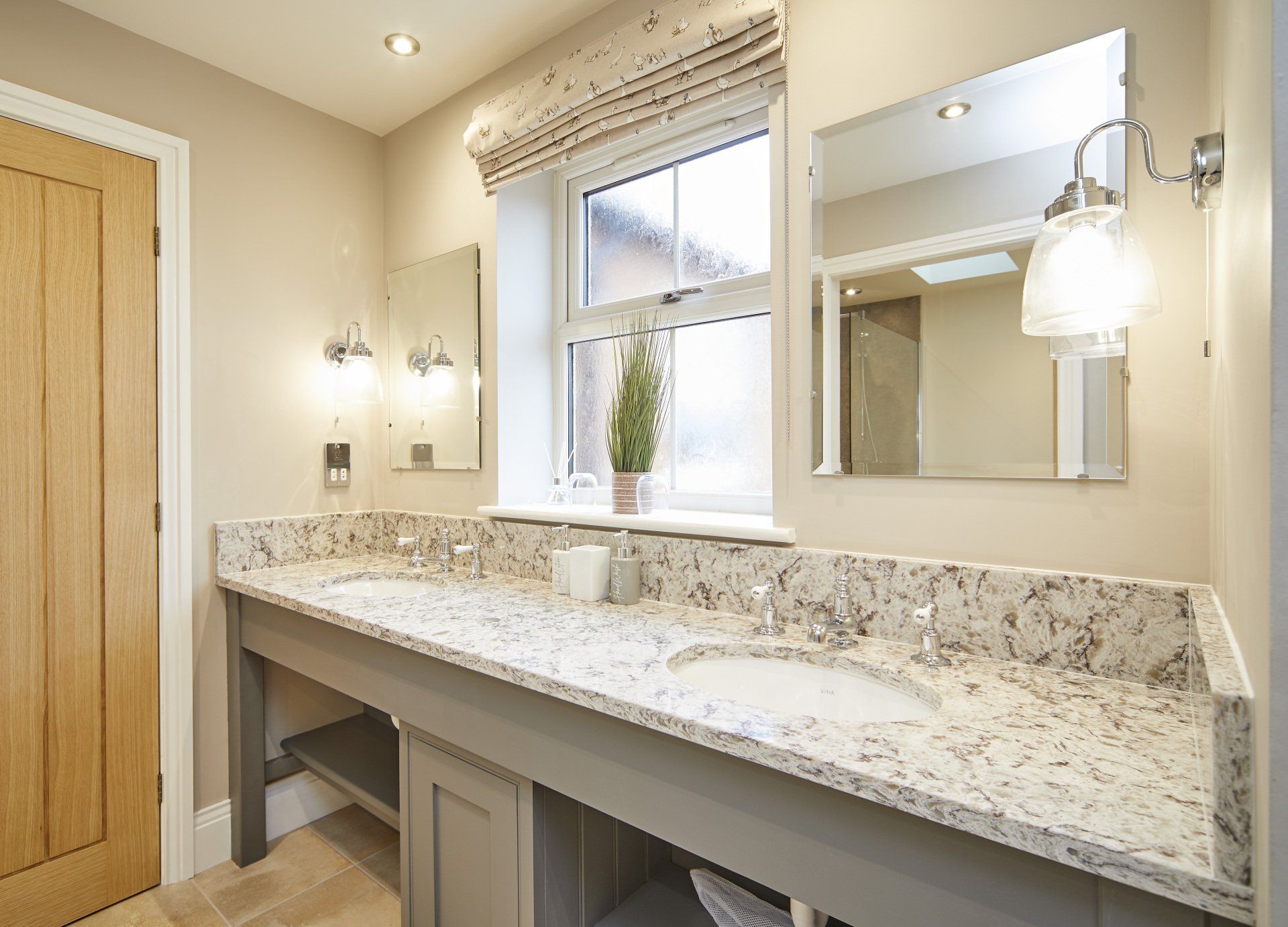 A bathroom with two sinks , a mirror and a window.