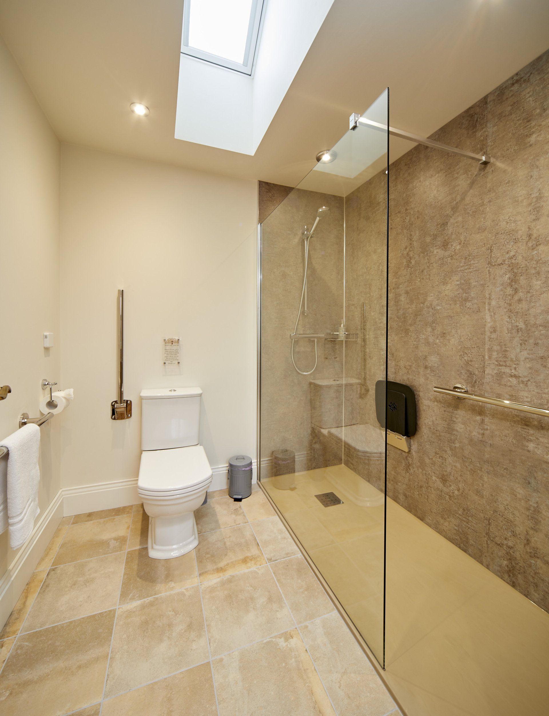 A bathroom with a toilet and a walk in shower