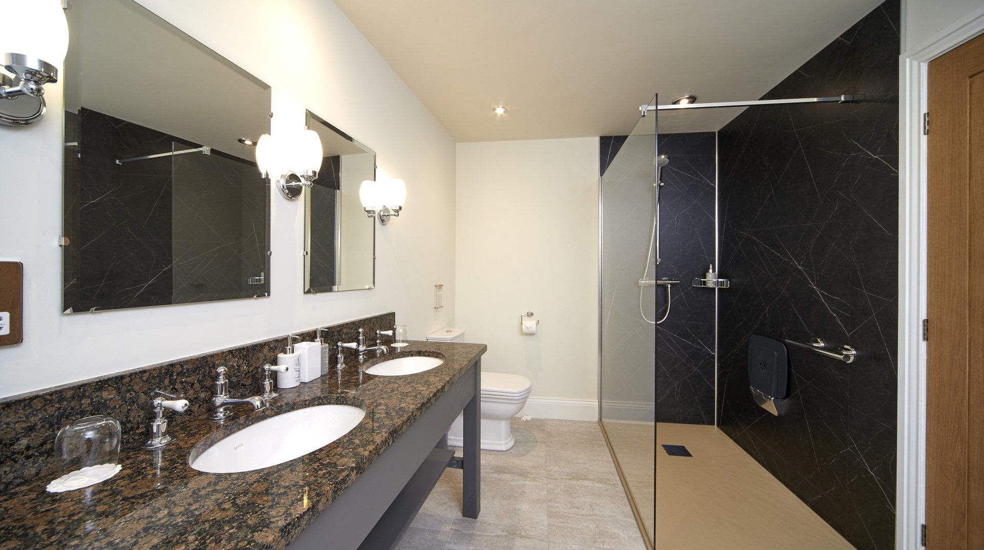 A bathroom with two sinks and a walk in shower