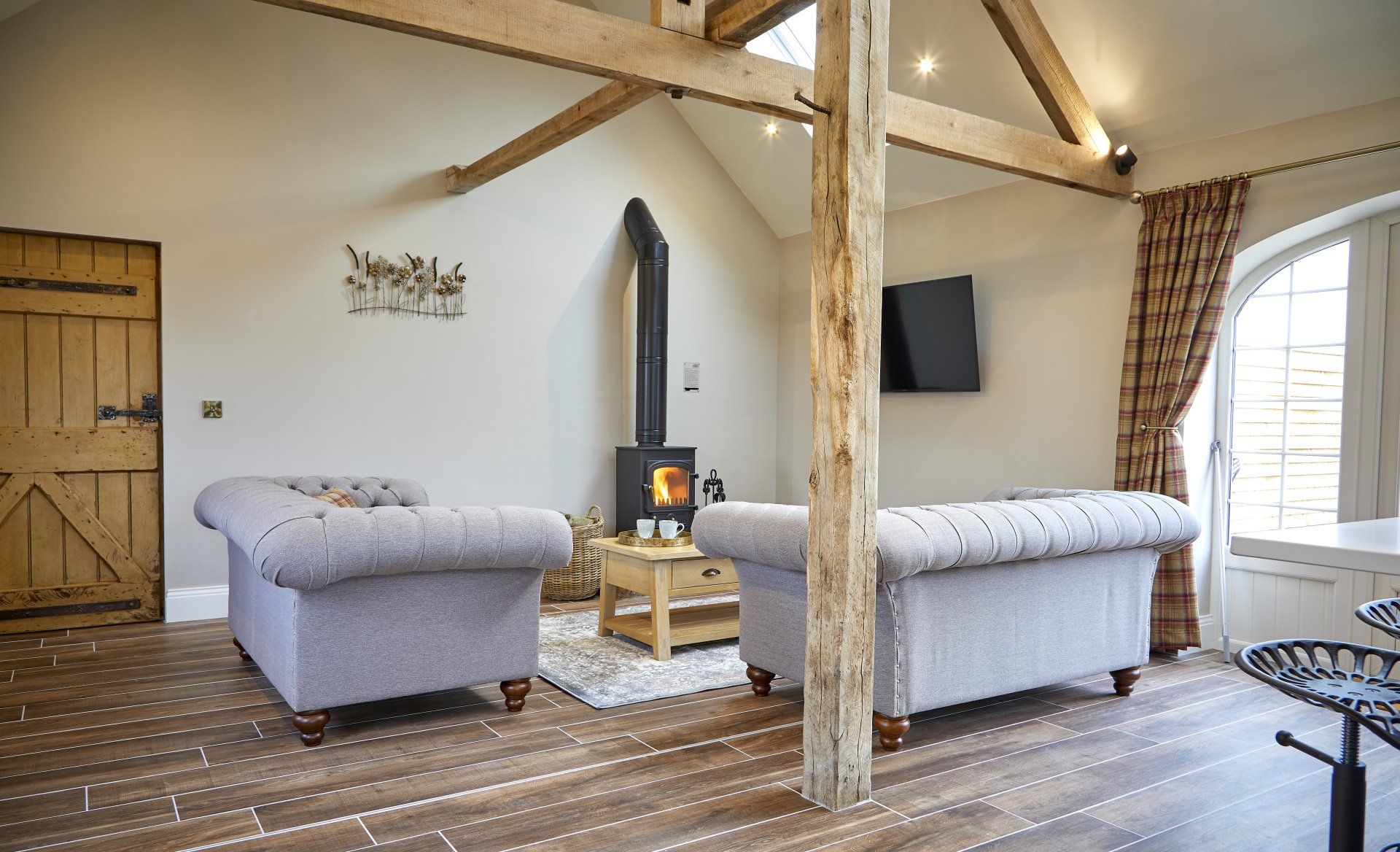 A living room with two couches and a wood stove.