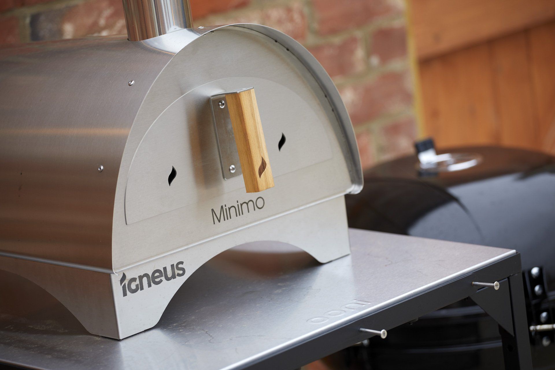 A stainless steel pizza oven is sitting on top of a metal table.