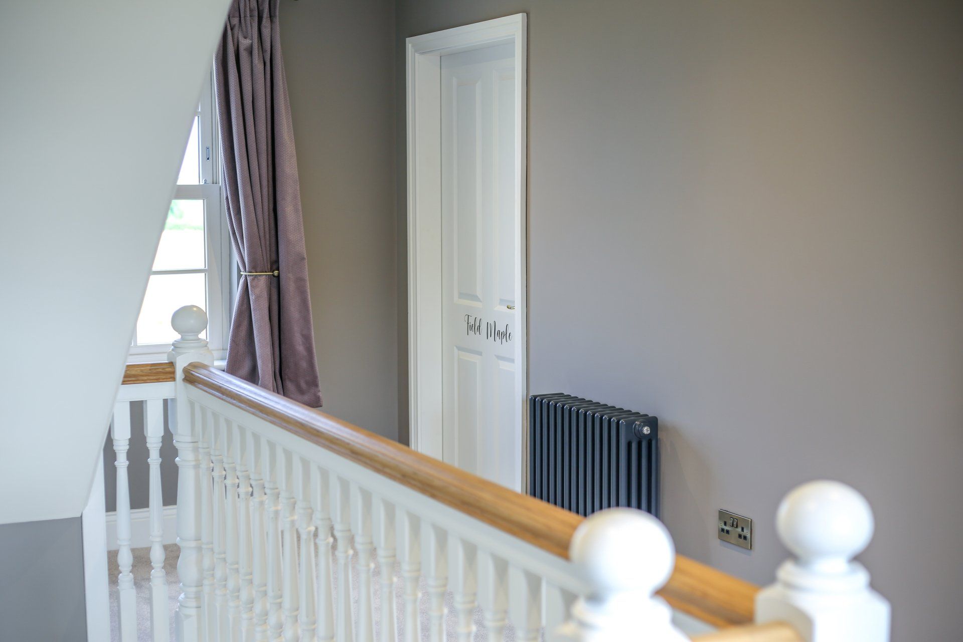 A staircase with a white railing and a radiator on the wall.