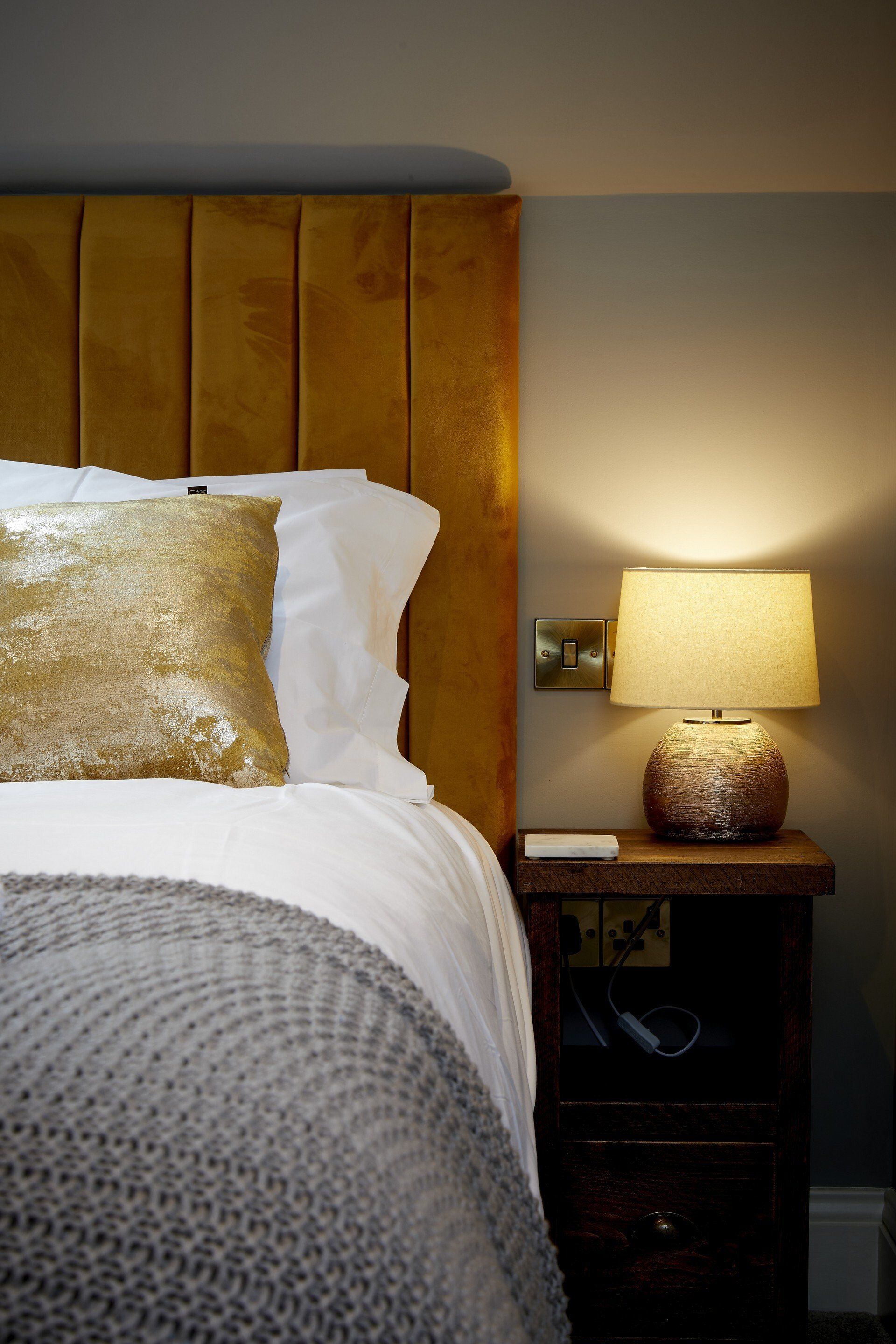 There is a lamp on the nightstand next to the bed.