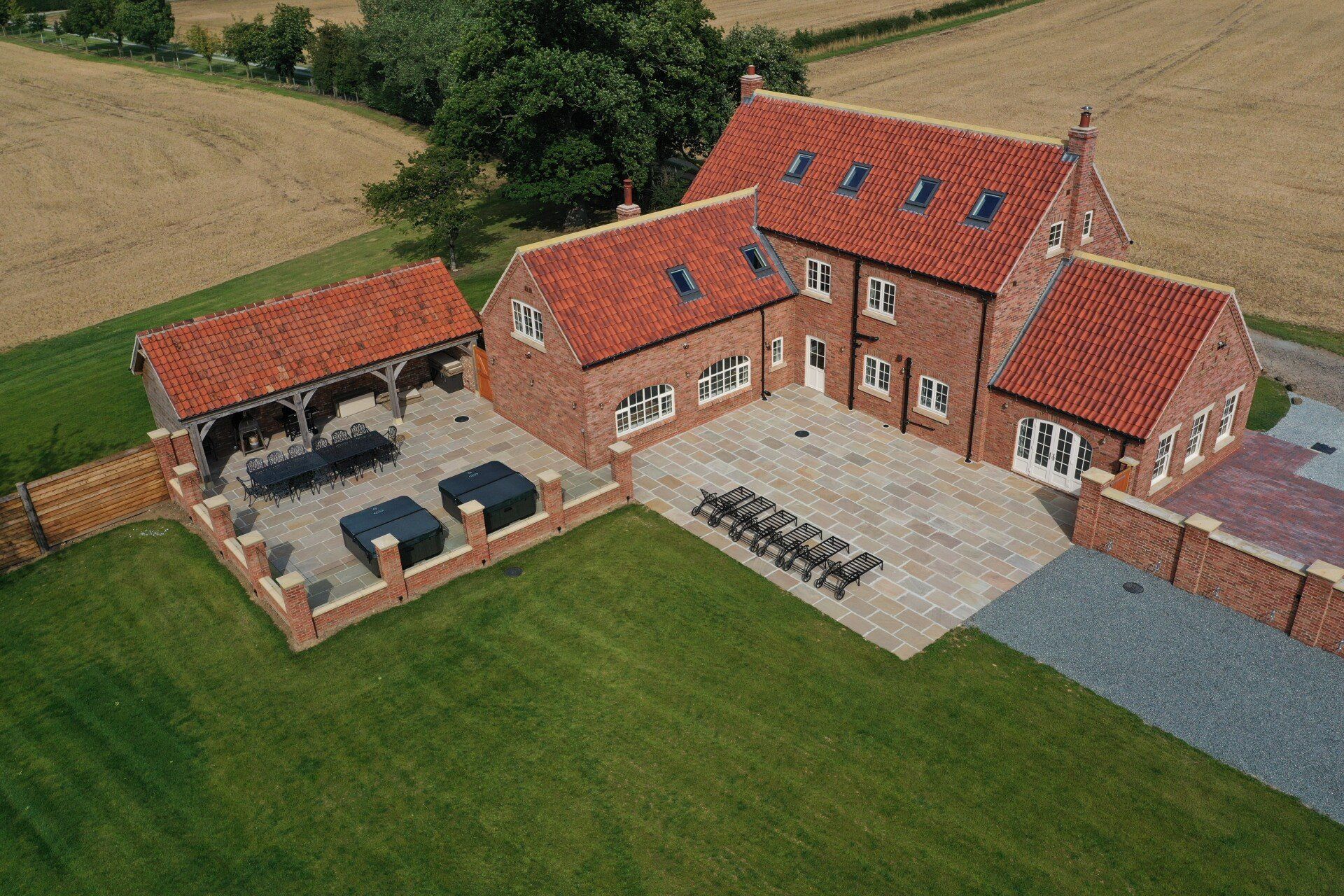 An aerial view of a large brick house with a large lawn in front of it.