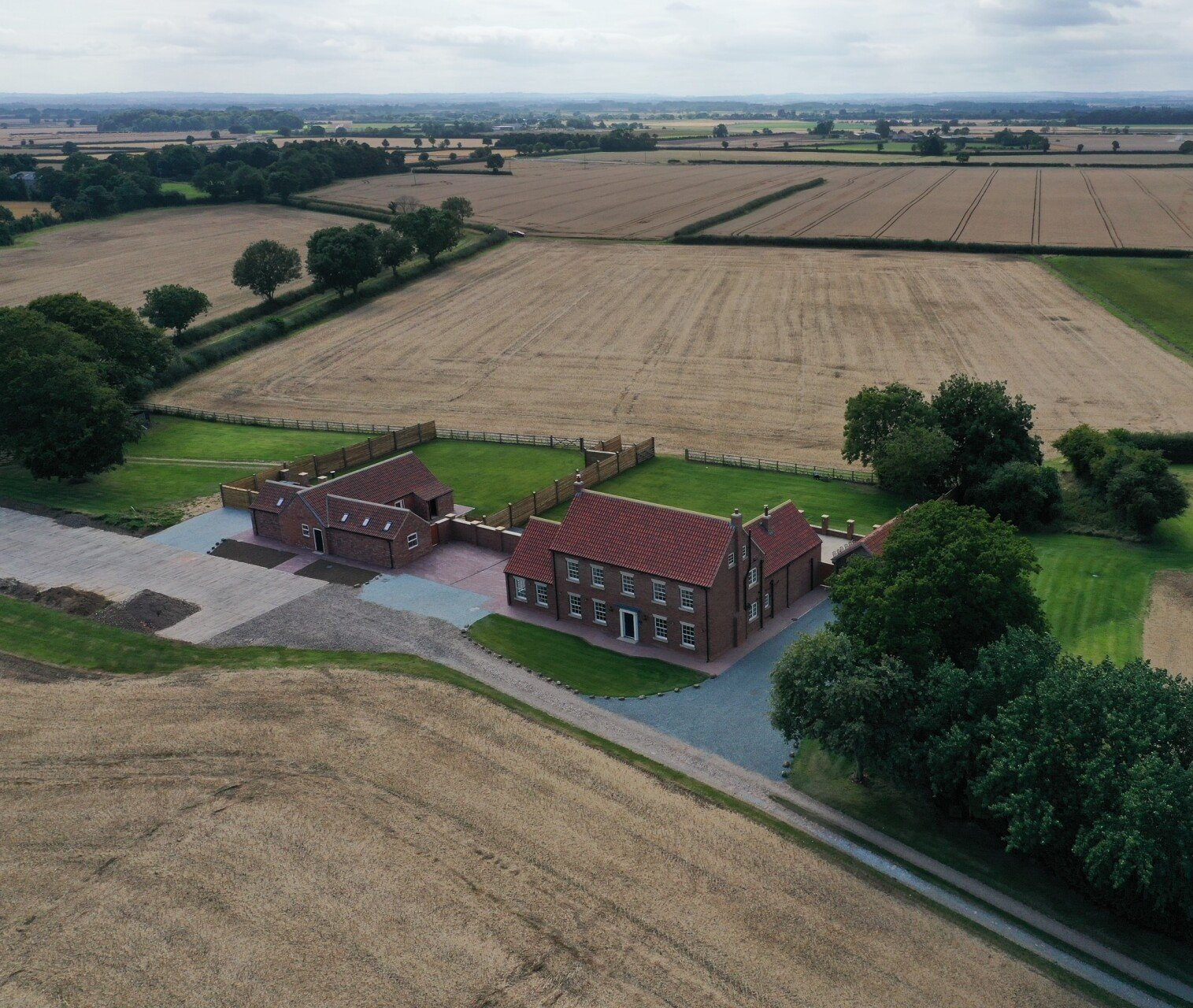 An aerial view of a house in the middle of a field