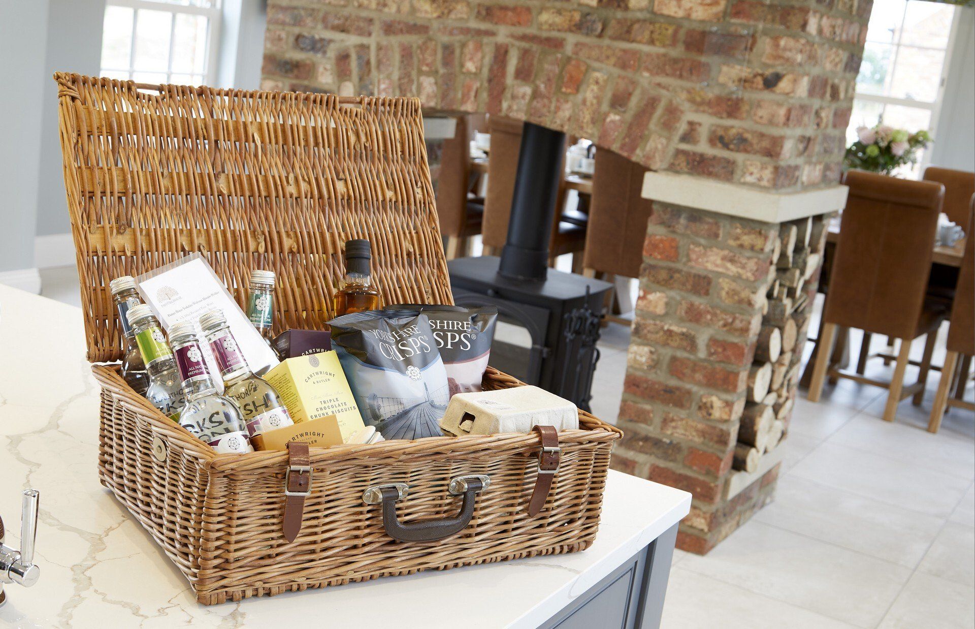 A wicker basket filled with food is sitting on a counter in a kitchen.