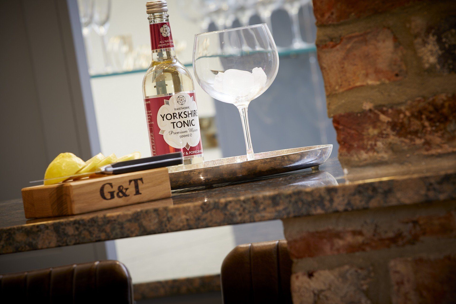 A bottle of gin and tonic is sitting on a counter next to a glass.