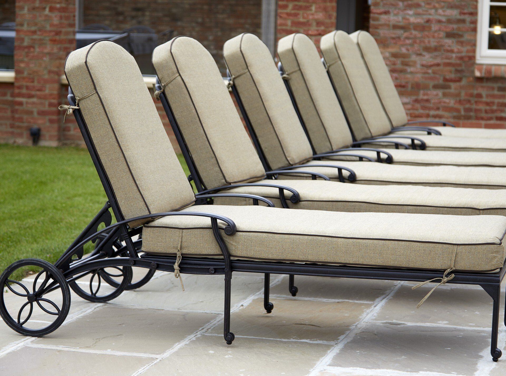 A row of lounge chairs are lined up on a patio