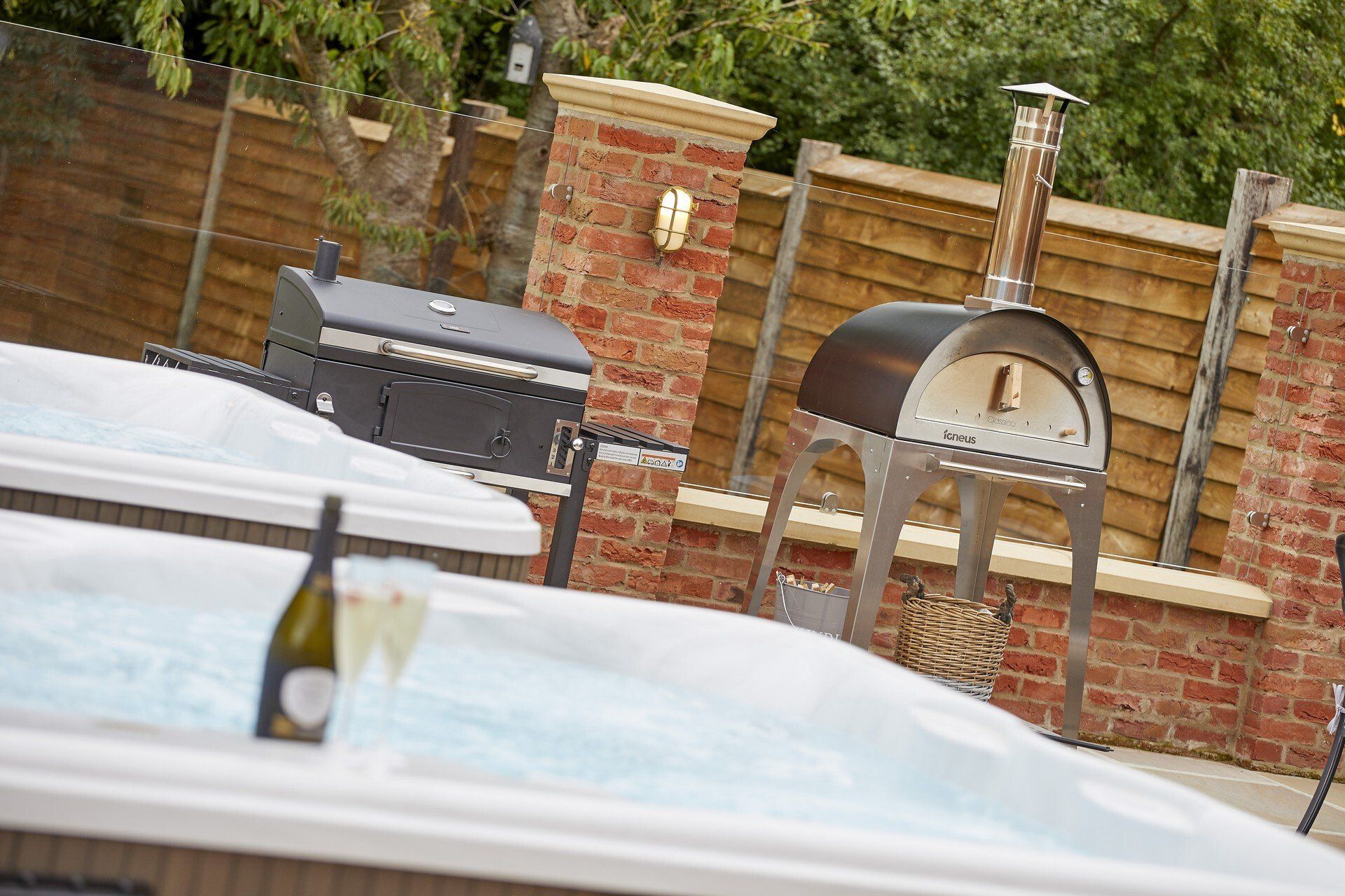 A hot tub with a bottle of wine and a glass of wine in it.