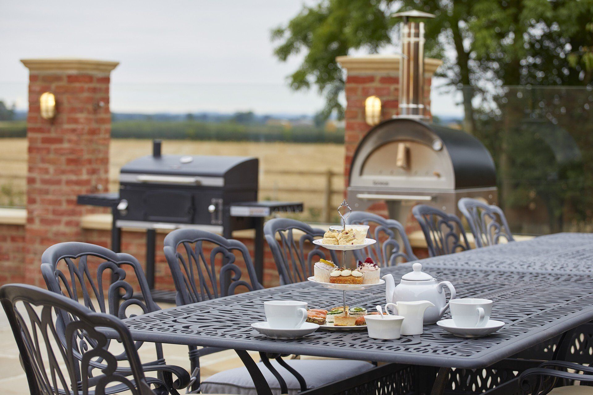 A patio table with a pizza oven in the background