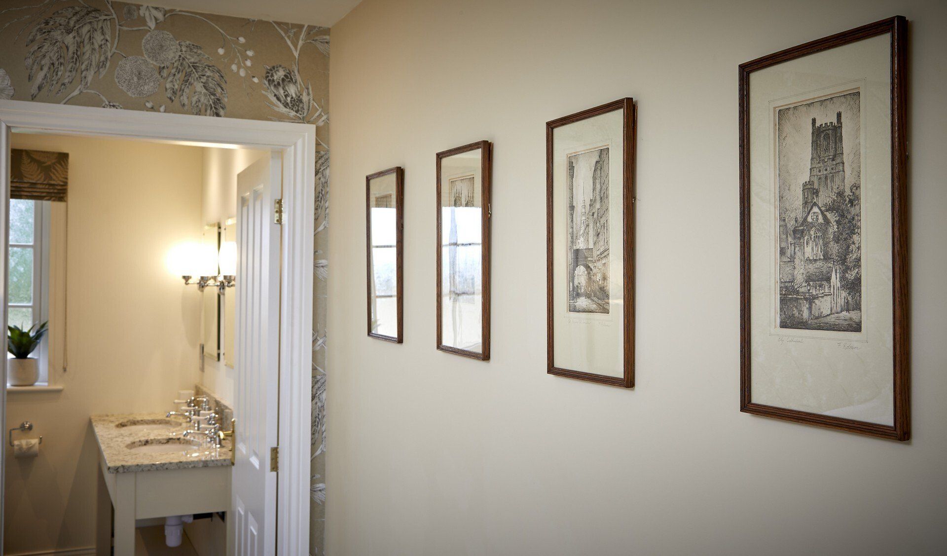 A bathroom with a sink and a row of framed pictures on the wall.