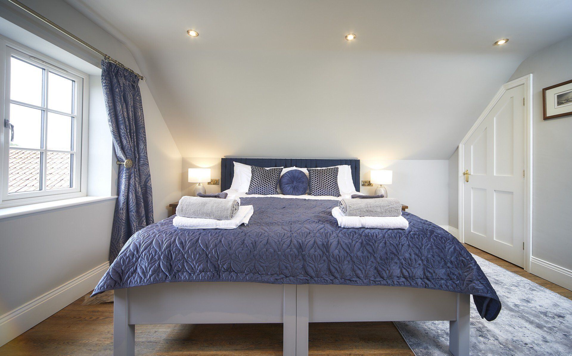 A bedroom with a king size bed and a window.