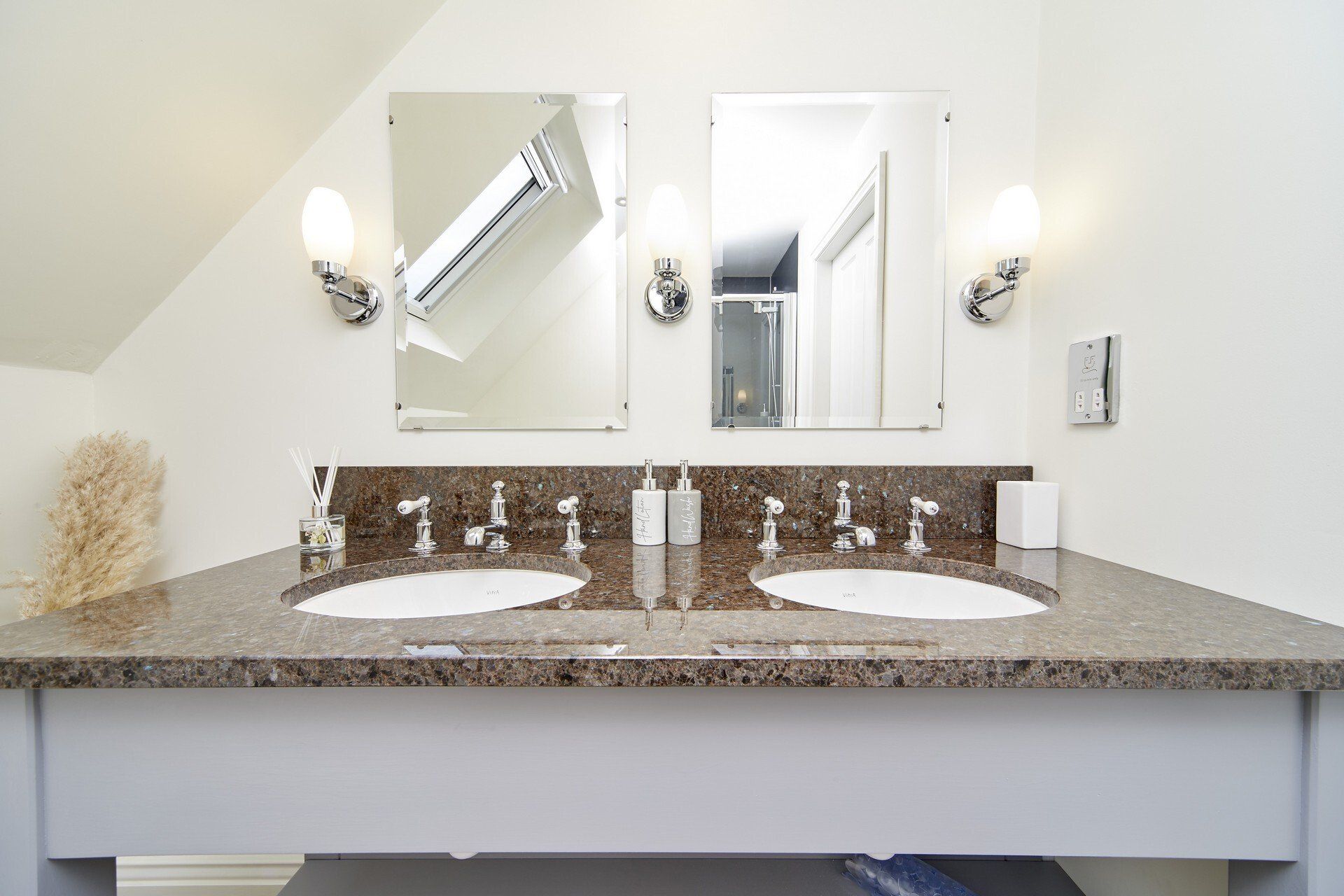 A bathroom with two sinks and two mirrors.