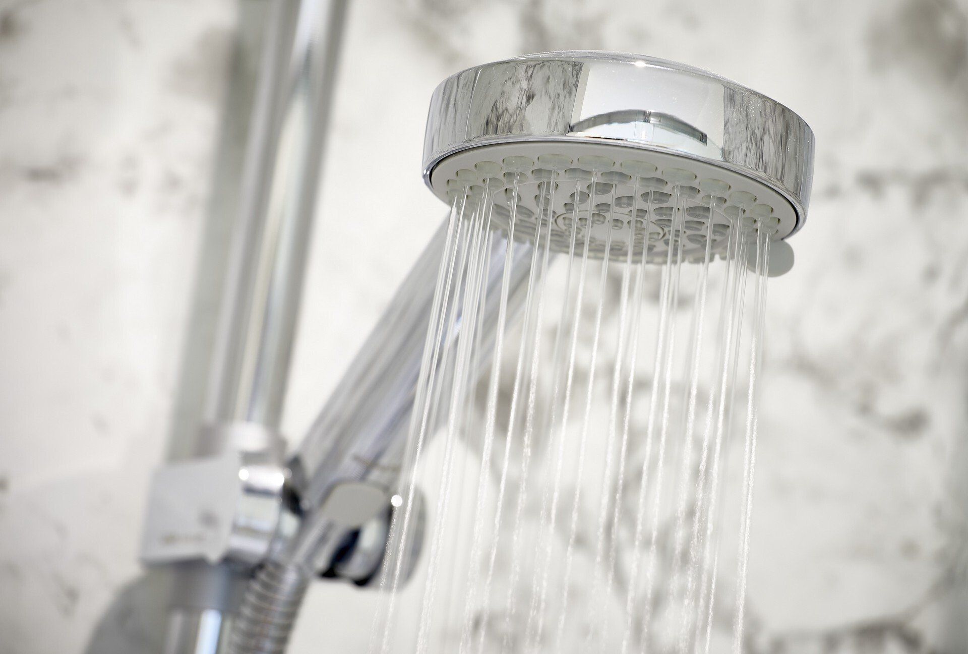 A close up of a shower head with water coming out of it.