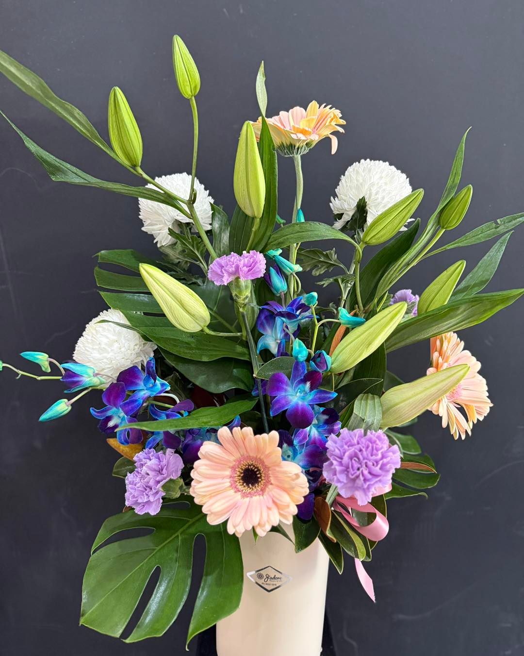 Hand Holding a Bouquet of Closed Lily Flowers โ J'adore Flowers & Gifts Cairns in Earlville, QLD