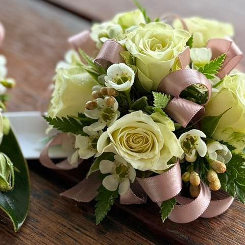 Close-up of a floral corsage with white roses, small white flowers, and a pink ribbon โ J'adore Flowers & Gifts Cairns in Earlville, QLD